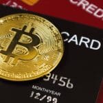 Een afbeelding van een bitcoin (BTC) munt op creditcards