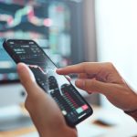 Een belegger kijkt grafieken op een mobiele telefoon