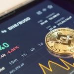 bitcoin BTC munt op een telefoon met een koersgrafiek