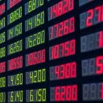 Een bord met marktdata, waaronder rode en groene cijfers voor crypto en aandeel handelaren