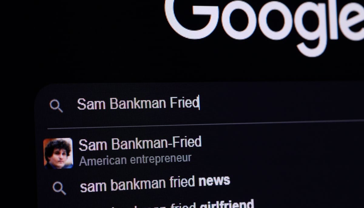 Een computer beeldscherm met de google zoekbalk, waar Sam Bankman-Fried (SBF) is ingevoerd, met verschillende zoeksuggesties