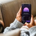 Vrouw op de bank met een telefoon en de kraken app