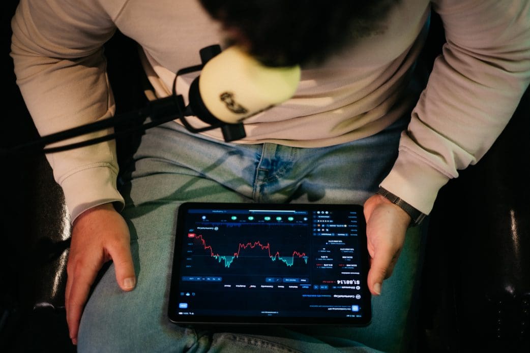 altcryptocast sjuul follings met tablet in handen kijkt naar koers