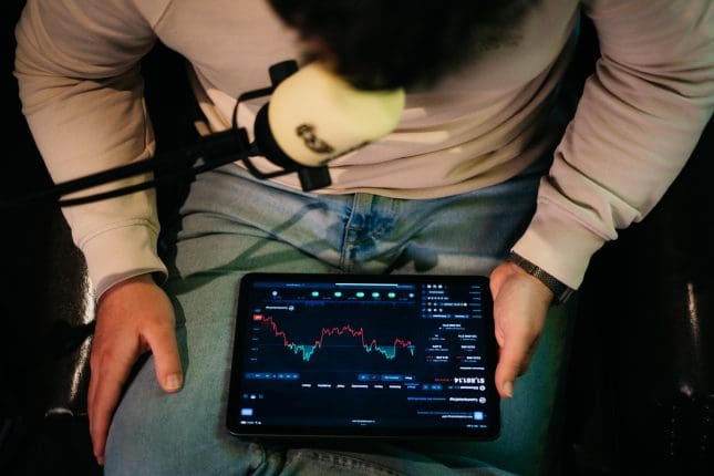 altcryptocast sjuul follings met tablet in handen kijkt naar koers