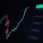 Een afbeelding met een groene, zeer snel stijgende candle chart van een crypto koers of aandelen koers