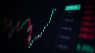 Een afbeelding met een groene, zeer snel stijgende candle chart van een crypto koers of aandelen koers