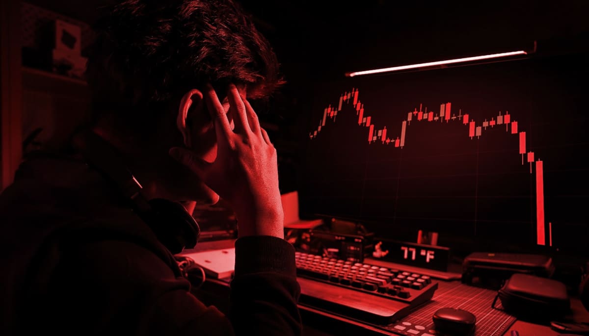 Een afbeelding met een rood filter waarbij een cryptohandelaar gefrustreerd en gestresst naar een hard gecrashte crypto koers kijkt