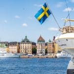 Een afbeelding van de Zweedse vlag aan de achterkant van een boot in de haven van Stockholm