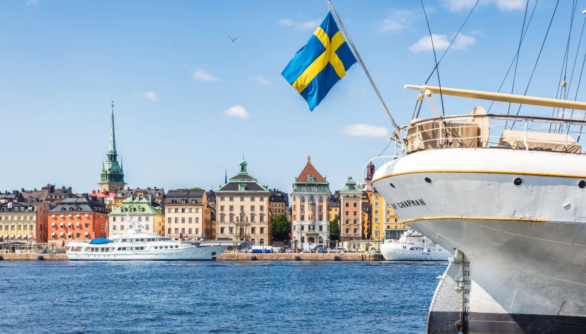Een afbeelding van de Zweedse vlag aan de achterkant van een boot in de haven van Stockholm