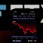 Een afbeelding van de failliete cryptobeurs FTX met het logo op de achtergrond, en op de voorgrond de rode gecrashte koers van hun token, FTT