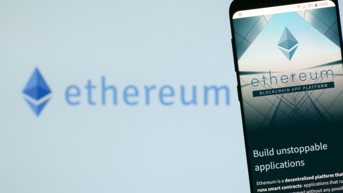 Een afbeelding van het ethereum (ETH) logo met daarnaast een mobiele telefoon met de website van de ethereum foundation