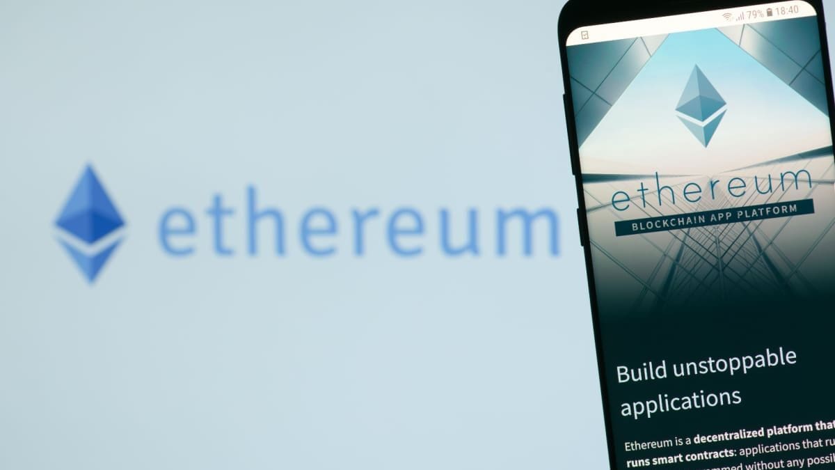 Een afbeelding van het ethereum (ETH) logo met daarnaast een mobiele telefoon met de website van de ethereum foundation