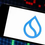 Een afbeelding van het logo van sui (SUI) op een mobiele telefoon, met op de achtergrond marktdata van crypto of een aandeel_aandelen