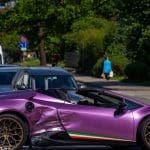 Een gecrashte paarse kapotte Lamborghini supercar, met de Italiaanse vlag op de zijkant en een spoiler op de achterkant