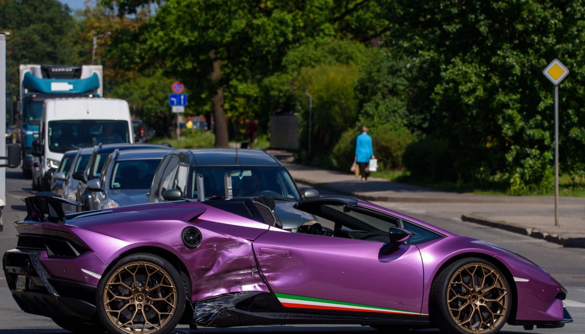 Een gecrashte paarse kapotte Lamborghini supercar, met de Italiaanse vlag op de zijkant en een spoiler op de achterkant