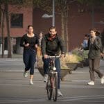 Nederlanders op een plein die fietsen, lopen, hardlopen en zitten