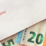 Een envelop van de Belastingdienst met daarin geld