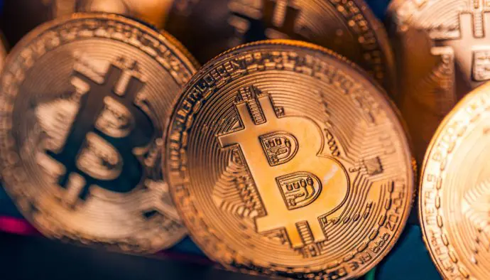 Verschillende gouden bitcoin (BTC) munten in een divers verlichte afbeelding