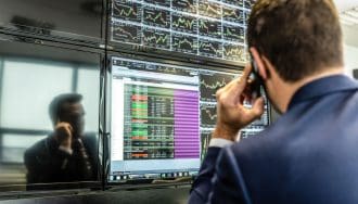 Man met telefoon belt en checkt grafieken