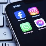 De verschillende apps van het bedrijf Meta_ Whatsapp, Instagram, Facebook en Messenger. De logo's van de apps staan op een Iphone