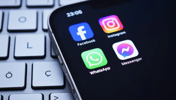 De verschillende apps van het bedrijf Meta_ Whatsapp, Instagram, Facebook en Messenger. De logo's van de apps staan op een Iphone