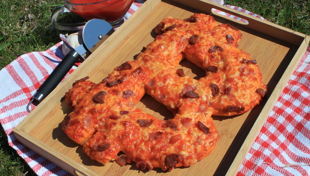 Een afbeelding van een pizza in de vorm van het bitcoin logo, ter ere van 'bitcoin pizza day'