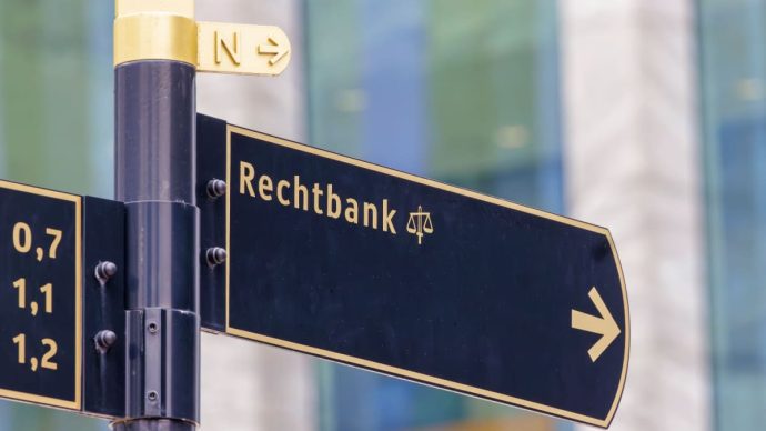 Een afbeelding van een verkeersbord die de richting aanwijst naar de rechtbank