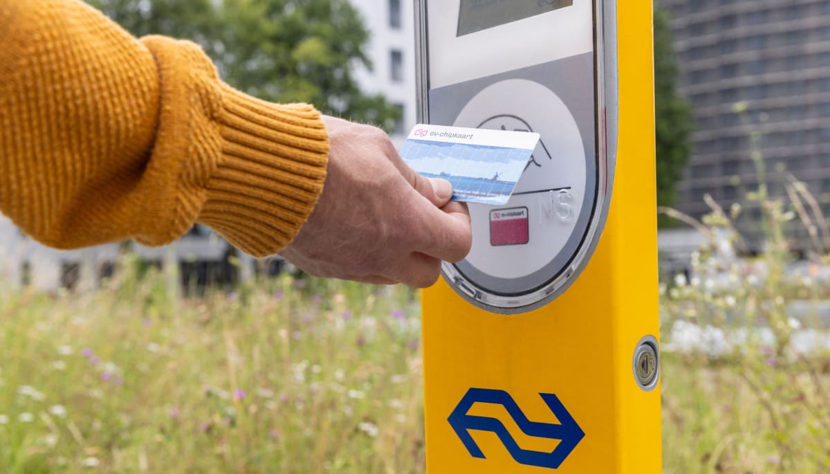 Een afbeelding van het openbaar vervoer waarbij een Nederlander een ov-chipkaart gebruikt om in te checken bij NS