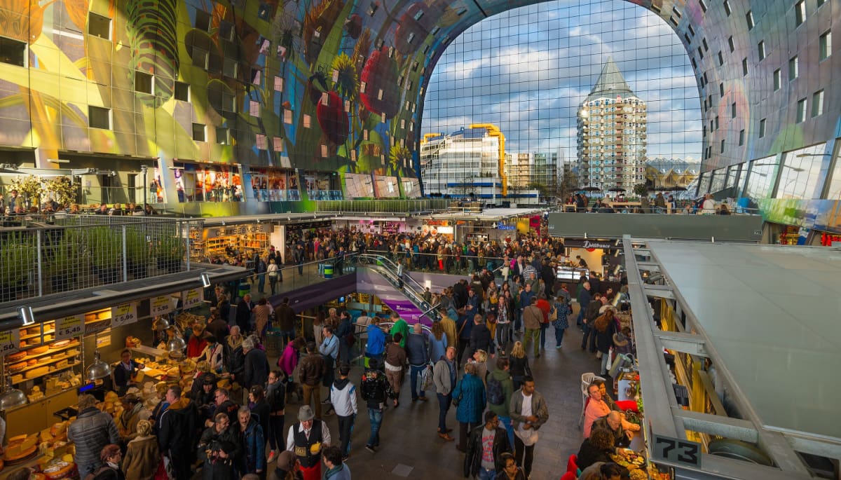 Een drukke afbeelding met veel mensen van de Rotterdamse markthal in Nederland