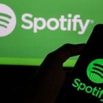 Twee keer het spotify logo met elk een ander contrast, waarvan een op een beeldscherm en een andere op een mobiele telefoon