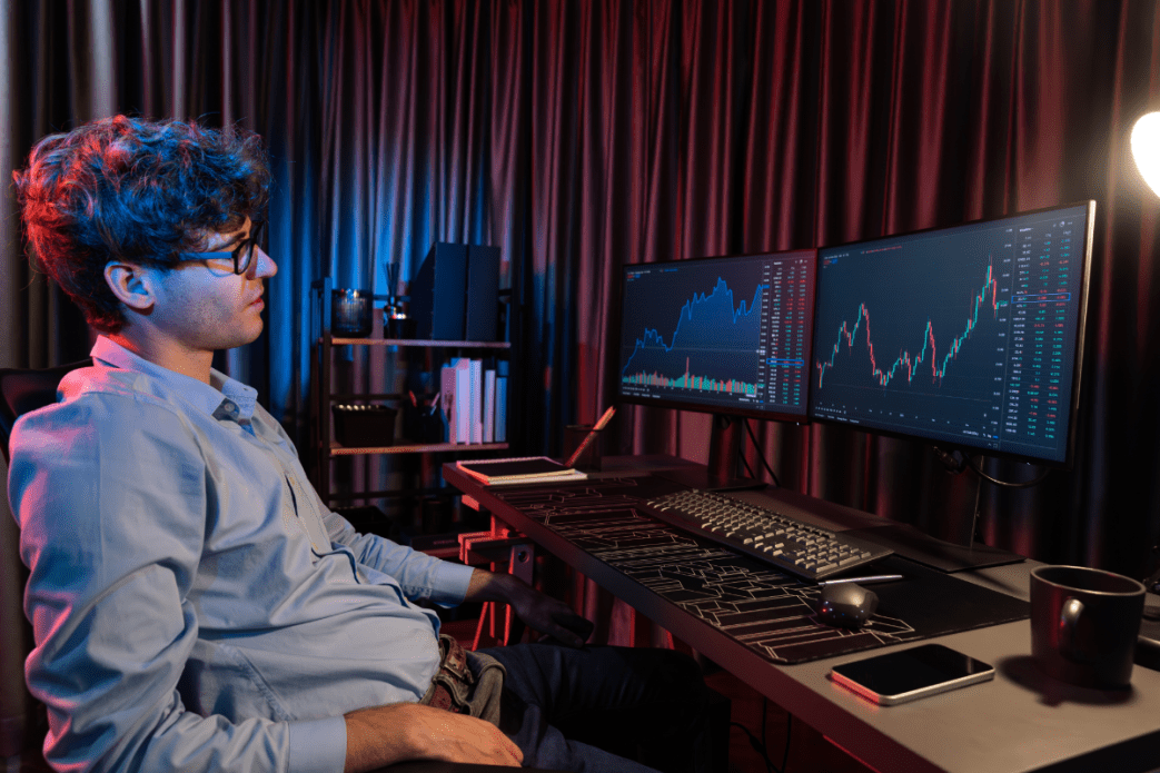 Man op laptop kijkt naar crypto grafieken