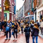 Een afbeelding van Nederlanders die wandelen en winkelen in de straten van Amsterdam