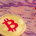 Een afbeelding van een bitcoin (BTC) munt naast een pin op het land Rusland