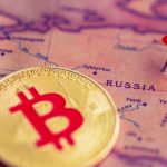 Een afbeelding van een bitcoin (BTC) munt naast een pin op het land Rusland