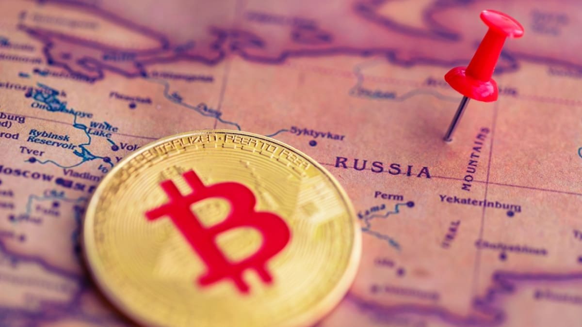 Een afbeelding van een bitcoin (BTC) munt naast een pin op het land Rusland
