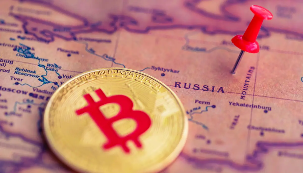 Een afbeelding van een bitcoin (BTC) munt naast een pin op het land Rusland