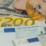 Een afbeelding van fysieke bitcoin cryptomunten op euro bankbiljetten