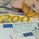 Een afbeelding van fysieke bitcoin cryptomunten op euro bankbiljetten