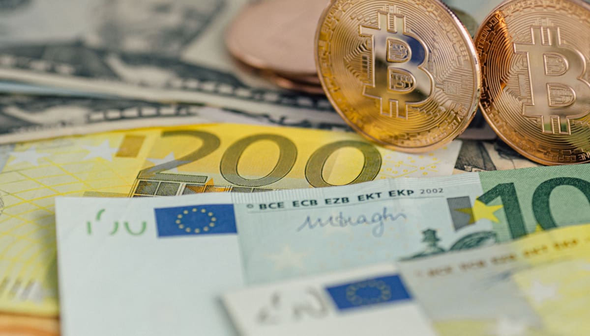 Een afbeelding van fysieke bitcoin cryptomunten op euro bankbiljetten
