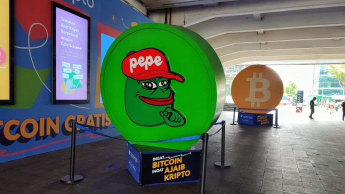 Een fysieke afbeelding van pepe coin (PEPE), een van de grootste memecoins van de cryptomarkt, op een crypto conferentie