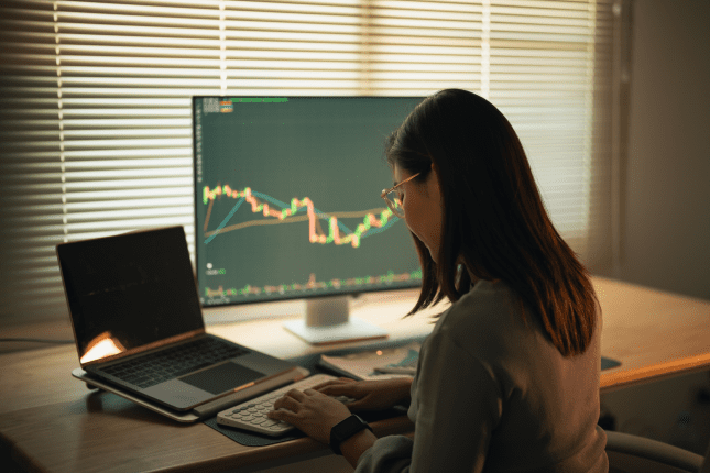 Trader laptop vrouw koers grafiek crypto
