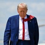 Een afbeelding van de Amerikaanse president Donald Trump die wegloopt van een helikopter, richting de camera