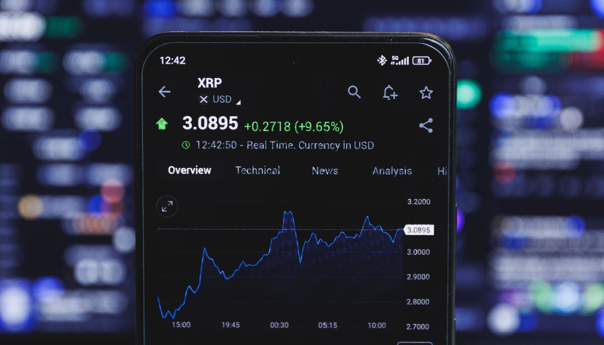 Een afbeelding van de XRP koers met groene cijfers en een hoop marktdata op de achtergrond