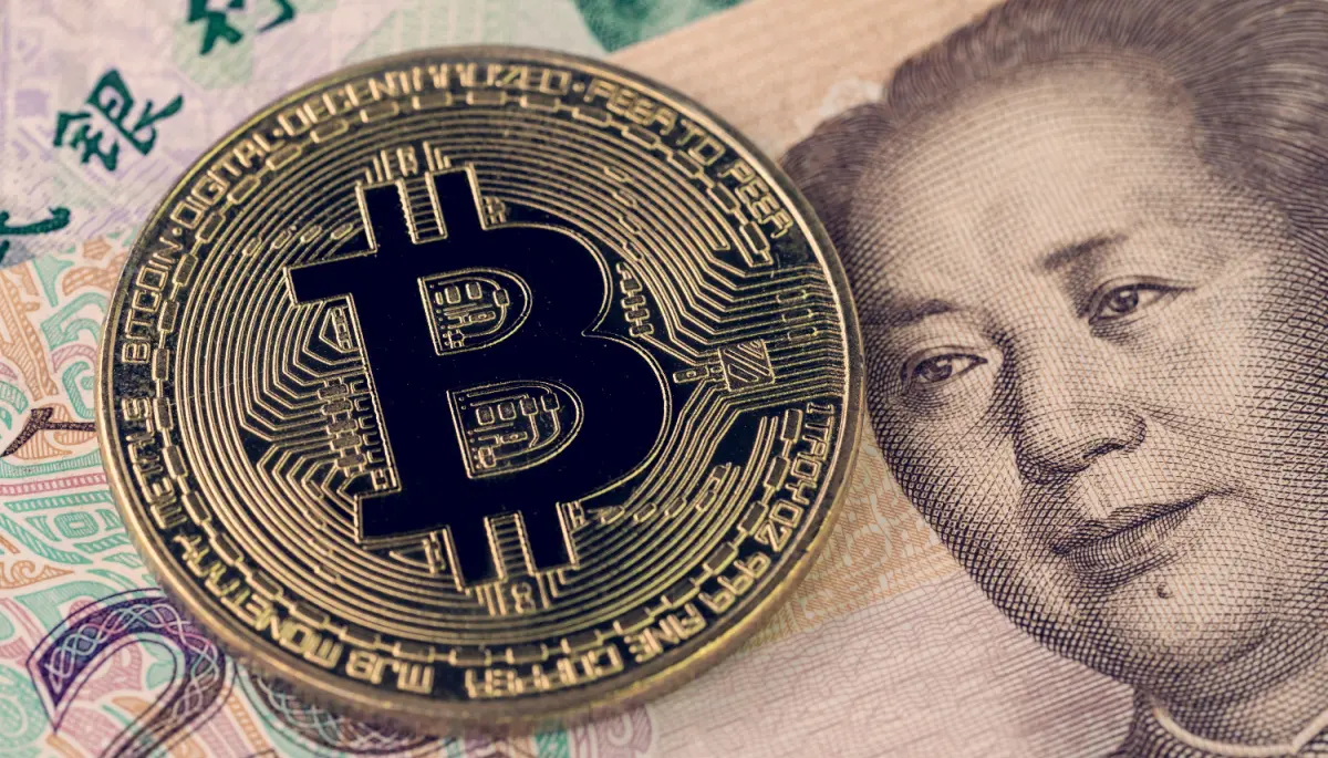 Een afbeelding van een bitcoin munt op een briefje van Chinees geld