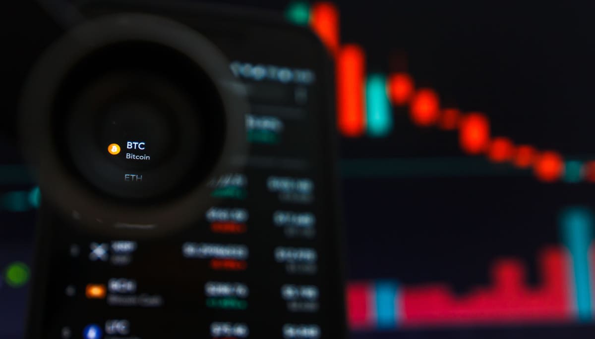 Een afbeelding van een bitcoin pagina op een marktdata website, met een rode koers op de achtergrond