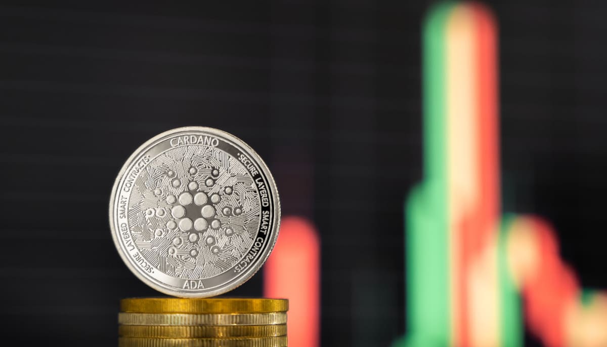 Een afbeelding van een cardano (ADA) munt met op de achtergrond een grafiek van een koers met een snelle prijsbeweging