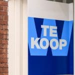 Een afbeelding van een koopbord aan de voorzijde van een huis