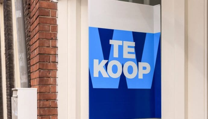 Een afbeelding van een koopbord aan de voorzijde van een huis