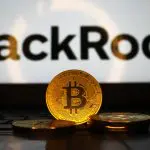 Een afbeelding van fysieke bitcoin munten voor een laptop met het BlackRock logo erop