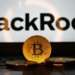 Een afbeelding van fysieke bitcoin munten voor een laptop met het BlackRock logo erop